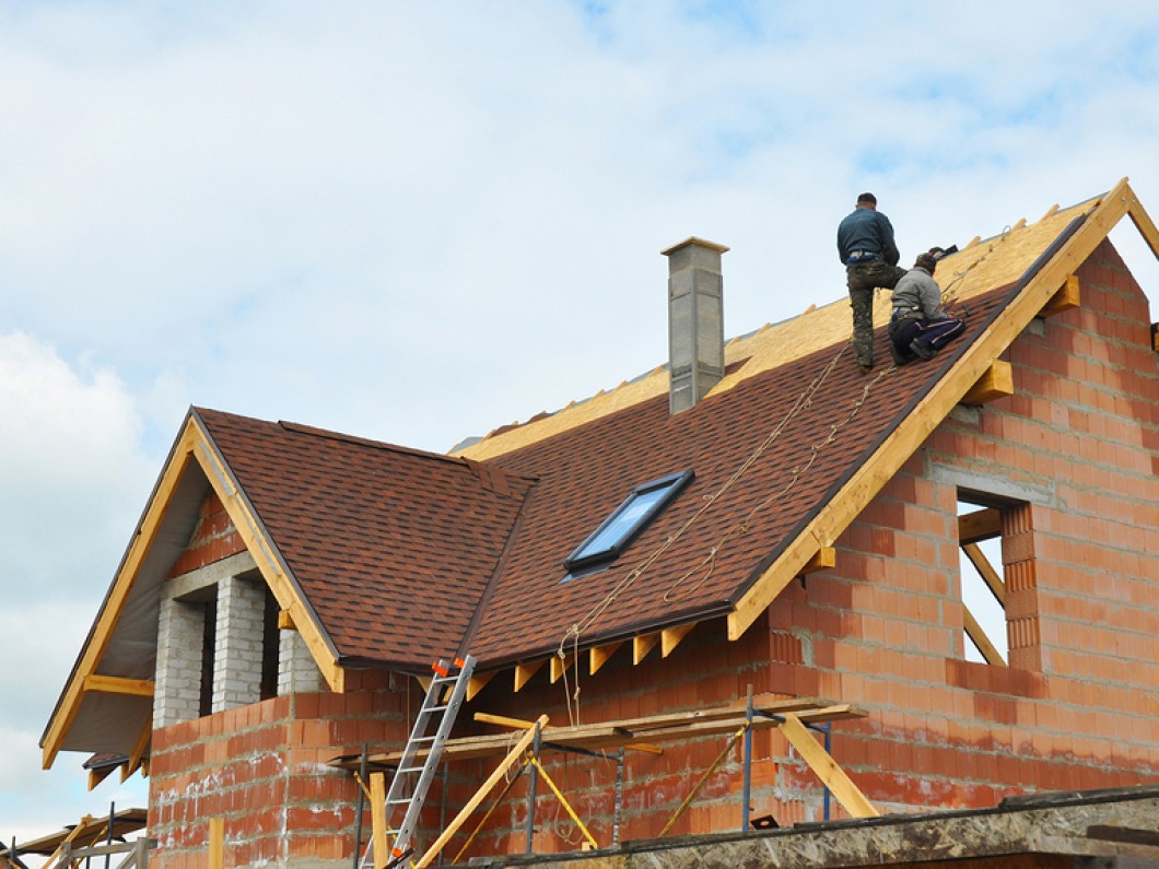 A man standing on the roof of a house