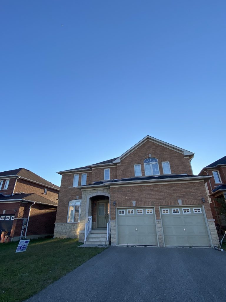 A house with two garage doors and a blue sky