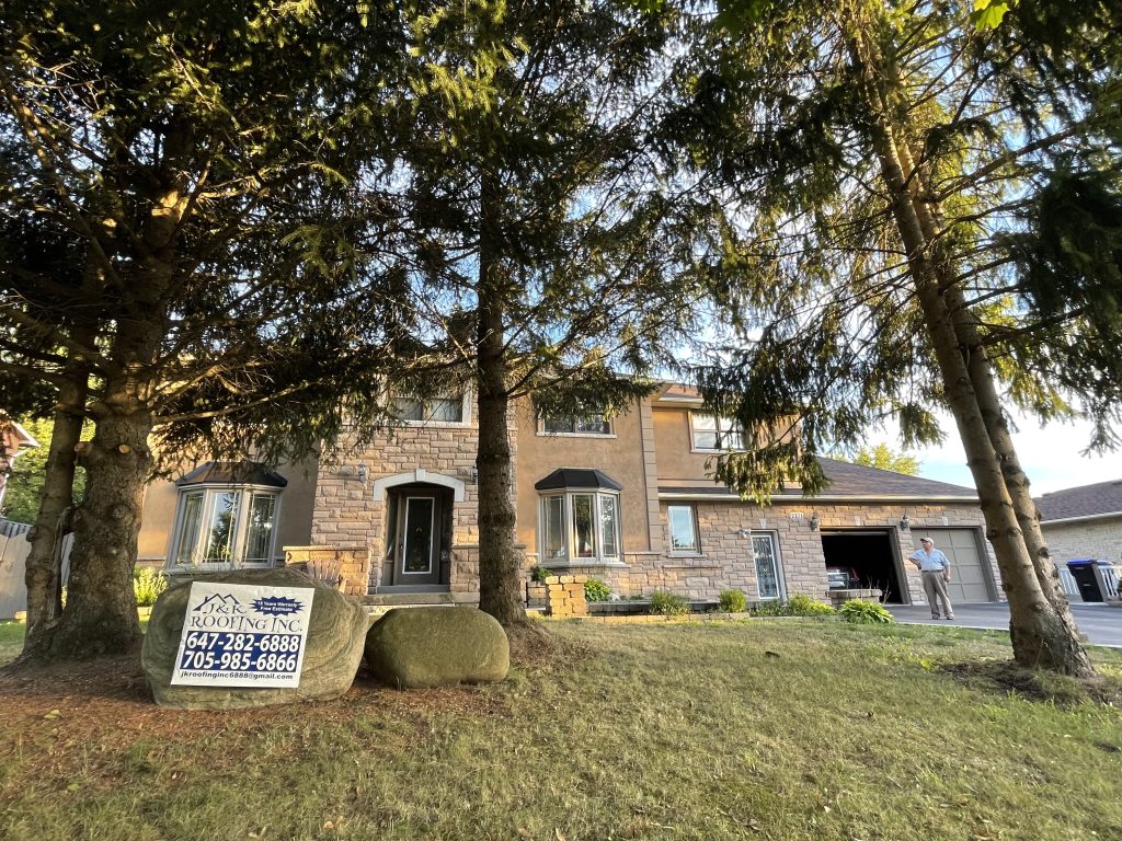 A large brick house with lots of windows and trees.