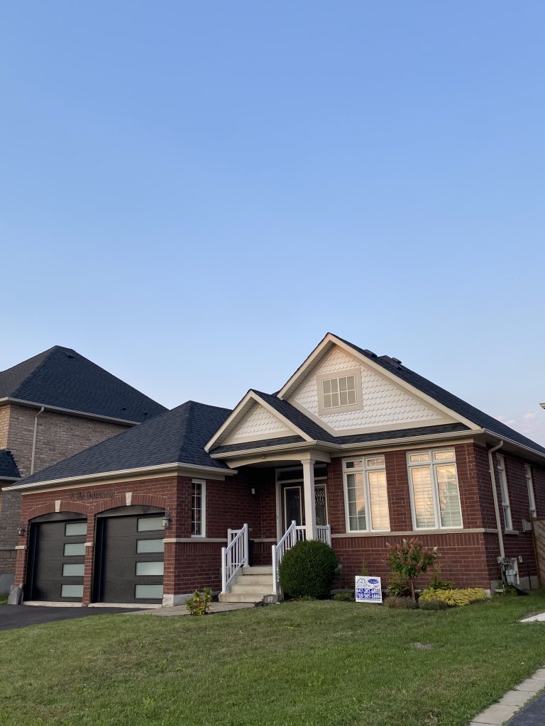 A house with two garage doors and a blue sky