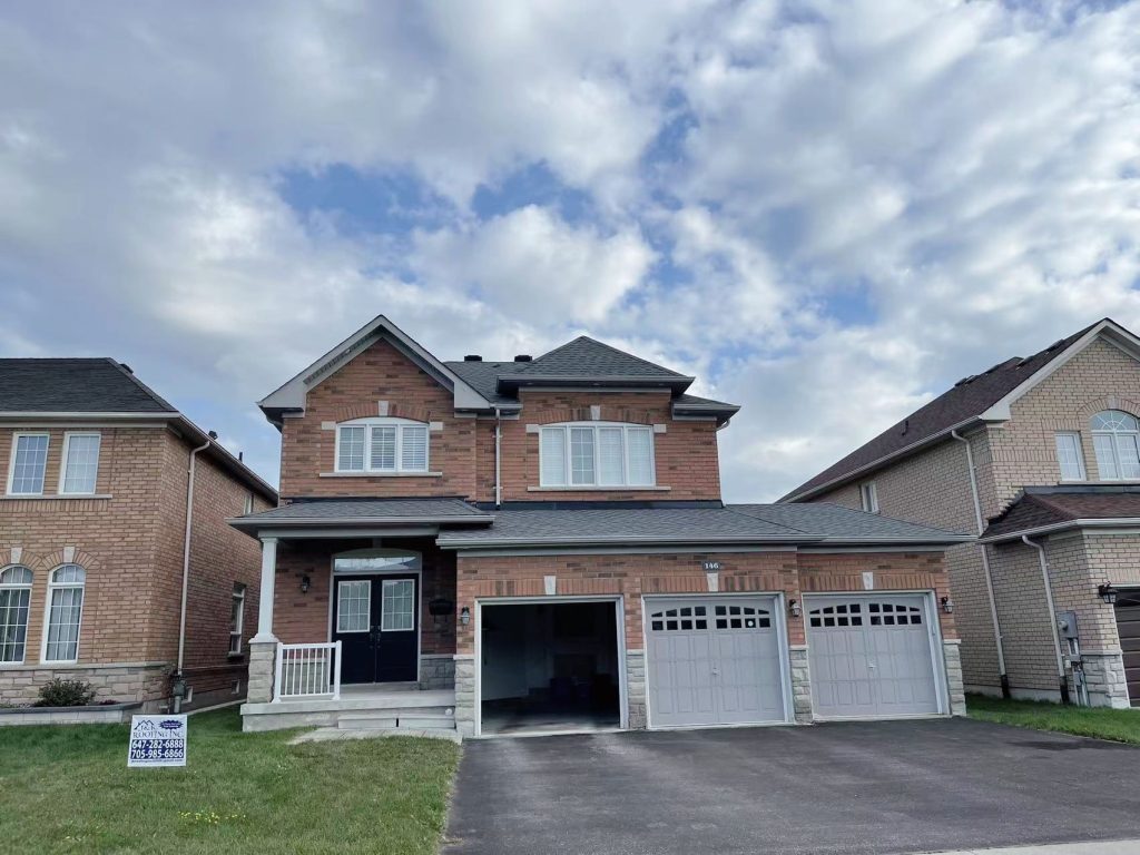 A large house with two garage doors and a sky background