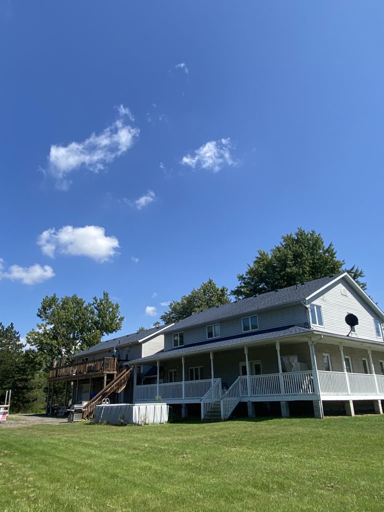 A large white house with a porch and deck.