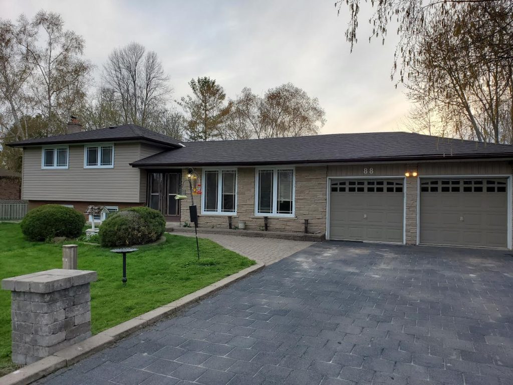 A large house with two garage doors and a driveway.
