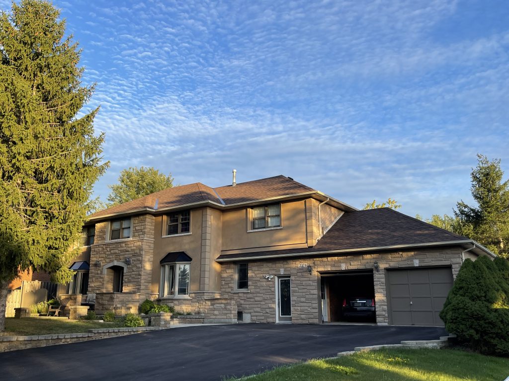 A large brick house with garage and driveway.
