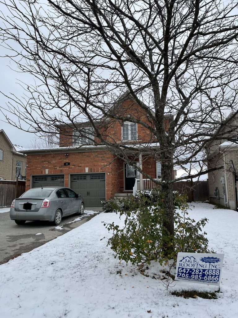 A car parked in front of a house with snow on the ground.