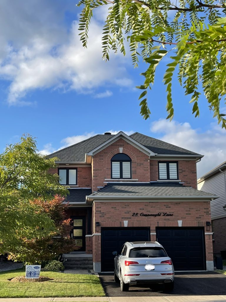 A car parked in front of a house with trees.
