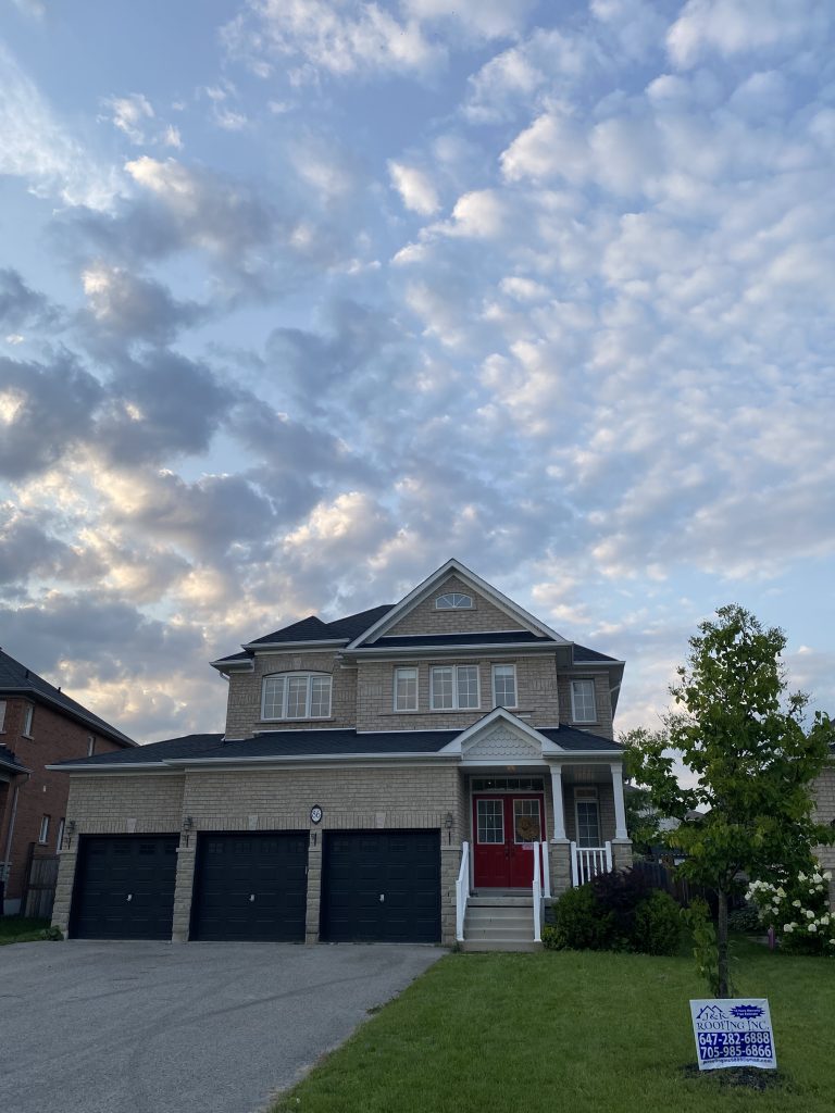 A house with two garage doors and a sky background