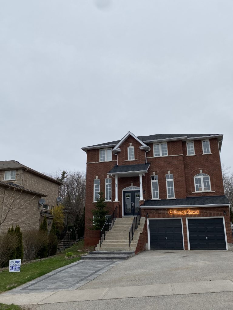 A large brick house with two garage doors.