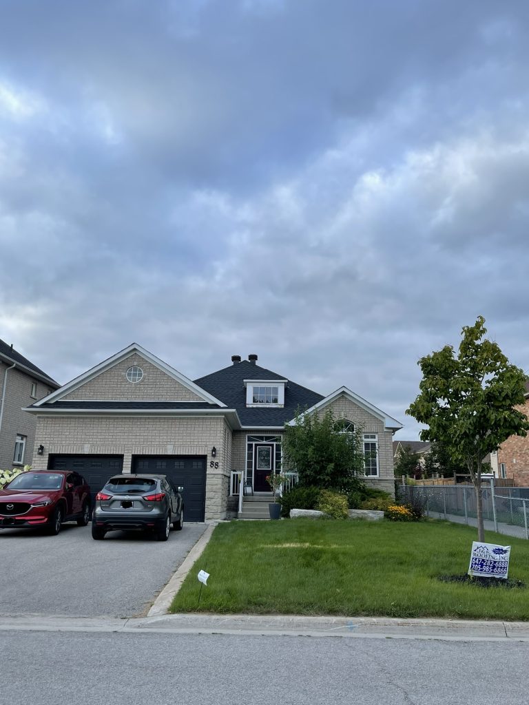 A house with two cars parked in front of it.